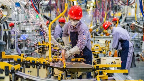 Các công nhân đang làm việc trên dây chuyền lắp ráp của một nhà máy thông minh thuộc công ty SERES Automobile Co., Ltd tại Trùng Khánh, Trung Quốc. Ảnh: Getty.