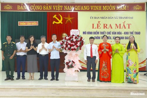 Lãnh đạo xã Thanh Oai tặng hoa chúc mừng Ban chủ nhiệm thiết chế văn hóa - khu thể thao thôn Tân Kiều. Ảnh: Mai Quý