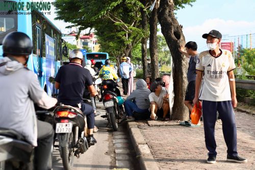 Nhu cầu về quê tăng cao, dọc tuyến Giải Phóng xuất hiện tình trạng người dân ngồi vỉa hè để bắt xe khách dọc đường. (Ảnh Thành Long)