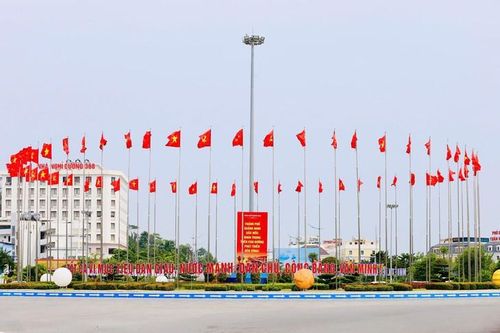 Những lá cờ Đảng, cờ Tổ quốc tung bay trong gió, tạo điểm nhấn tại khu vực vòng xuyến. Ảnh: Nguyễn Thanh Tùng