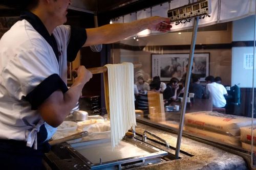  Một nhân viên đang chuẩn bị mì udon tại nhà hàng ở Tokyo. Ảnh: Louise Delmotte/Bloomberg. 