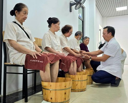 Người cao tuổi ngâm chân bằng thảo dược, xoa bóp bấm huyệt và dùng ghế massage
