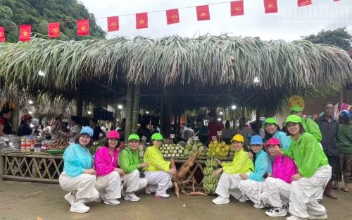 Các du khách chụp ảnh lưu niệm tại các gian hàng ở chợ phiên xã Muổi Nọi. (Ảnh: QUỐC TUẤN)