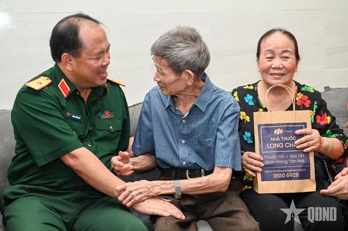 Thiếu tướng Đoàn Xuân Bộ thăm, tặng quà ông Nguyễn Xuân Viên (93 tuổi, cựu tù chính trị Côn Đảo). Ảnh: XUÂN CƯỜNG 