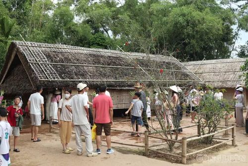 Nhiều du khách lặng người trước căn nhà tranh đơn sơ nơi gia đình Bác từng sống. Ảnh: Kim Long