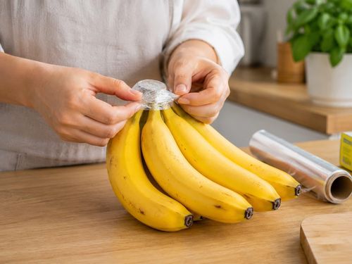 Phần cuống của quả chuối chín được bọc bằng màng bọc thực phẩm giúp bảo quản chuối được lâu. Ảnh minh họa: AI