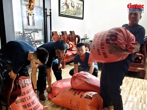Cán bộ, chiến sĩ hỗ trợ người dân di chuyển, sắp xếp tài sản sau khi nhà ở bị ảnh hưởng bởi ngập lụt.