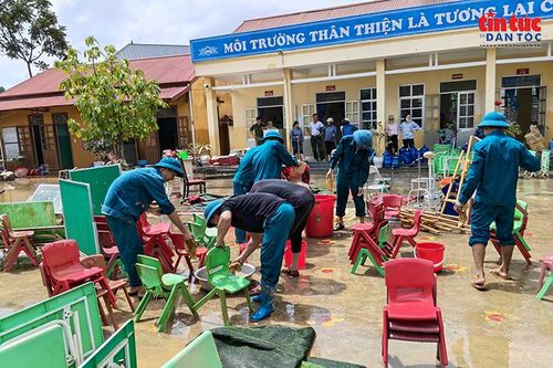 Lực lượng địa phương khẩn trương vệ sinh bàn ghế, đồ dùng học tập tại một trường học trên địa bàn xã Tràng Định.