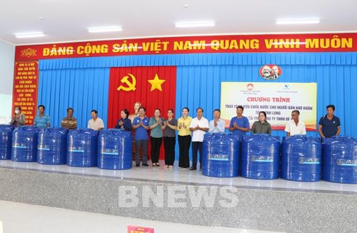 Trao bồn nước cho người dân xã Hòa Minh. Ảnh: Thanh Hòa-TTXVN