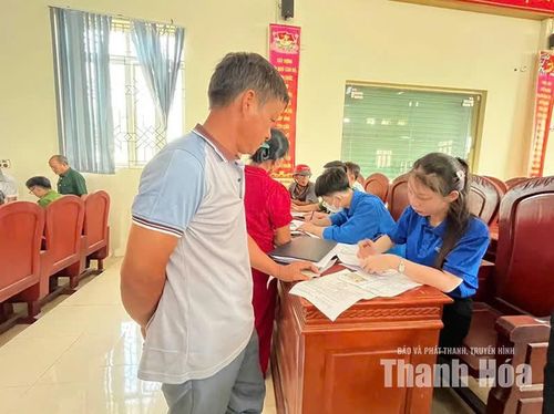 Đoàn thanh niên phường Ngọc Sơn hướng dẫn thân nhân liệt sĩ kê khai thông tin đăng ký lấy mẫu ADN. (Ảnh địa phương cung cấp)