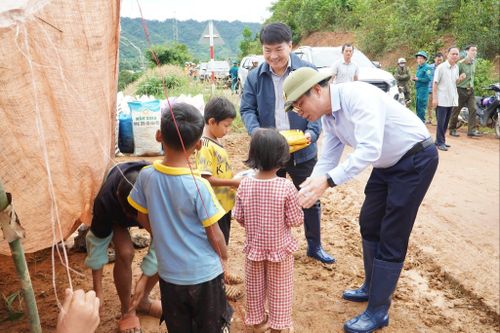 Phó Bí thư Tỉnh ủy, Chủ tịch HĐND tỉnh Lưu Văn Trung tặng quà cho các cháu đi tránh lũ cùng gia đình trong chuyến khảo sát tình hình ngập lụt, sạt lở tại xã Quảng Phú. Ảnh: Hoàng Hoài