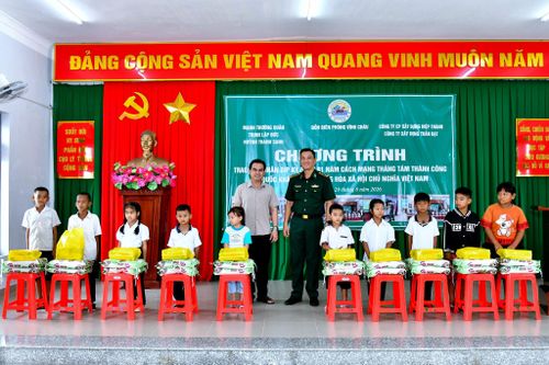 Thượng tá Phạm Nguyễn Thế Phong và đại diện mạnh thường quân trao quà cho các em học sinh tại chương trình. Ảnh: Văn Long