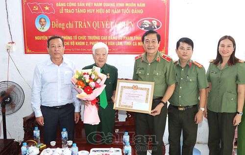 Thiếu tướng Hồ Việt Triều trao Huy hiệu 60 năm tuổi Đảng và tặng hoa chúc mừng đồng chí Trần Quyết Chiến.