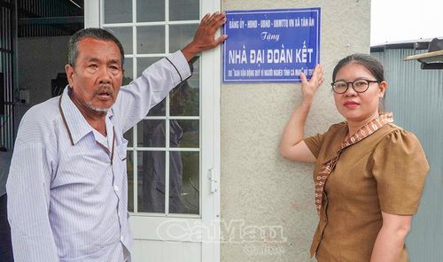 Bà Nguyễn Thị Thậm, Phó Chủ tịch Uỷ ban MTTQ Việt Nam xã Tân Ân gắn bảng nhà Đại đoàn kết cùng gia đình ông Nguyễn Văn Tấn, ấp Bảo Vĩ.