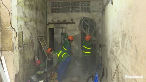 Lực lượng chức năng hỗ trợ gia đình ông Bạch Đăng Hà tháo dỡ, di chuyển tài sản. Ảnh: Lại Tấn