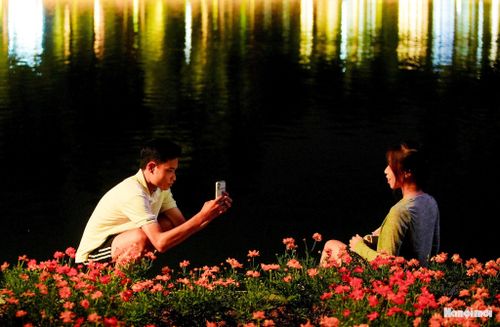 Đôi bạn trẻ tranh thủ lưu lại khoảnh khắc đẹp bên hồ Hoàn Kiếm.