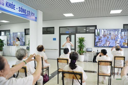 Nhân viên y tế hướng dẫn các cụ tập luyện. Ảnh: Tuấn Anh