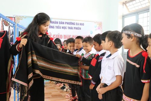 Học sinh Trường Tiểu học Thái Phiên (Đắk Lắk) tìm hiểu sản phẩm dệt thổ cẩm của đồng bào người Ê Đê. Ảnh: Tường Quân – TTXVN