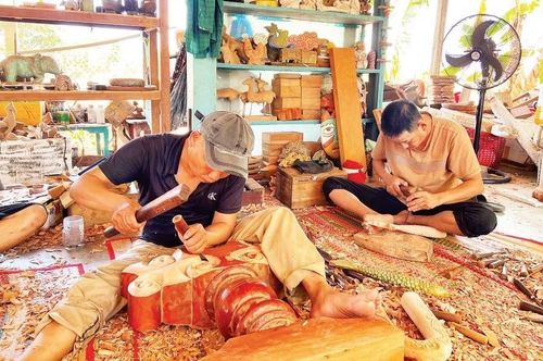 Thợ thủ công chế tác sản phẩm điêu khắc làm từ củi lũ tại làng Củi Lũ (phường Hội An Tây, thành phố Đà Nẵng).