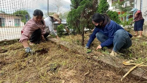 Giáo viên Trường nội trú liên cấp Thu Lũm dọn dẹp khuôn viên nhà trường. (Ảnh: Trần Tuấn)
