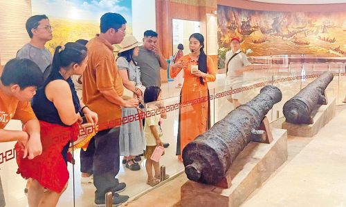  Du khách tham quan khu vực trưng bày vũ khí thời Tây Sơn. 