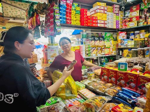 Khách hàng quét mã QR thanh toán tại một sạp tạp hóa ở chợ Vĩnh Hải.