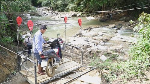 Nhờ cáp treo mà mưa lũ nước suối dâng cao nhưng người dân vẫn đi lại được.