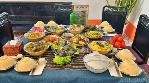 Mâm cơm với 11 món ăn truyền thống của người Tày ở Bắc Hà, như: Gà đen luộc, vịt lam ống nứa, canh cá nấu măng chua, phở chua, bánh chưng đen...