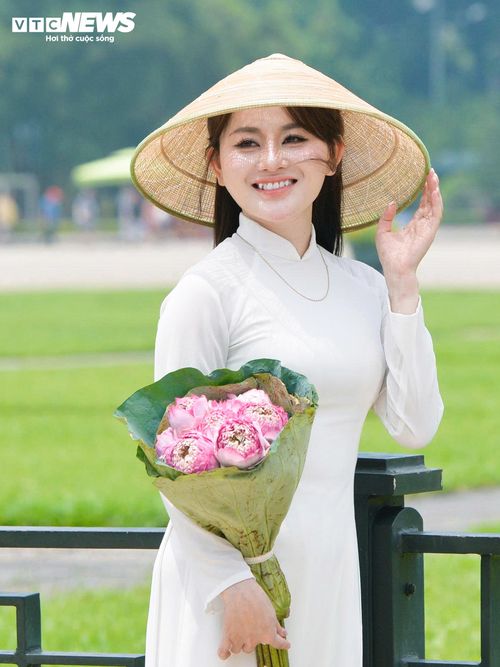 Nhiều bạn trẻ chuẩn bị khá kỹ cho buổi chụp ảnh. Người mang theo bó sen hồng, người đội nón lá in hình cờ Tổ quốc, người chọn khăn rằn hoặc hoa sen làm phụ kiện.