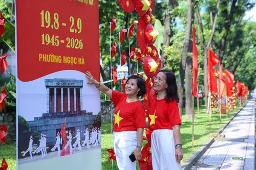 Người dân chụp ảnh bên pano trên phố Kim Mã. Ảnh: T.Anh.