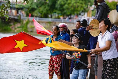 Người dân đến xem, cổ vũ lễ hội đua, bơi thuyền trên sông Kiến Giang. Ảnh: PV.