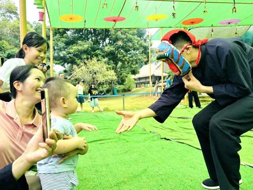 Khách du lịch đến Làng thích thú và mãn nhãn với màn múa kỳ lân của đồng bào dân tộc Nùng đến từ Cao Bằng