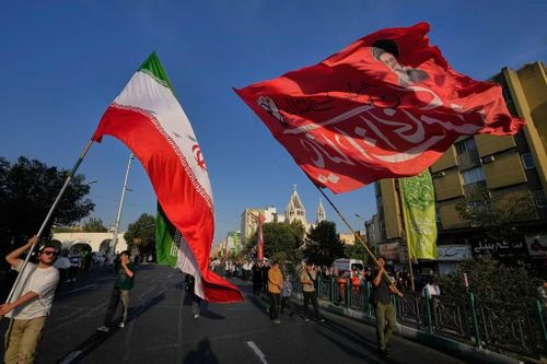 Quốc kỳ Iran và cờ in chân dung cố Lãnh tụ Tối cao Ali Khamenei trong lễ kỷ niệm mừng ngày sinh của Nhà tiên tri Muhammad trên đường phố Tehran ngày 30/8. (Ảnh: AP)