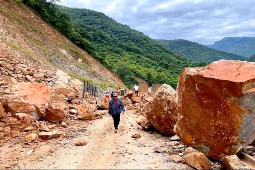 Đá núi sạt xuống mặt đường khiến giao thông trên tỉnh lộ 543D bị ách tắc.