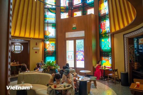 Cửa hàng mới mang đậm dấu ấn giao thoa giữa kiến trúc Pháp cổ và cảm hứng văn hoá Việt – nổi bật với trần nhà mô phỏng nón lá, đường cong Hồ Gươm uyển chuyển, cùng ánh sáng lung linh phản chiếu qua lớp kính màu nghệ thuật. (Ảnh: Minh Sơn/Vietnam+)