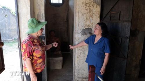 Anh hùng lực lượng vũ trang nhân dân Võ Thị Hóa (áo xanh) và bà Phạm Thị Thu, những người từng bị giam cầm tại Nhà lao Hội An, thăm lại khu vực xà lim, hay còn gọi là khu biệt giam. (Ảnh: Đỗ Trưởng/TTXVN)