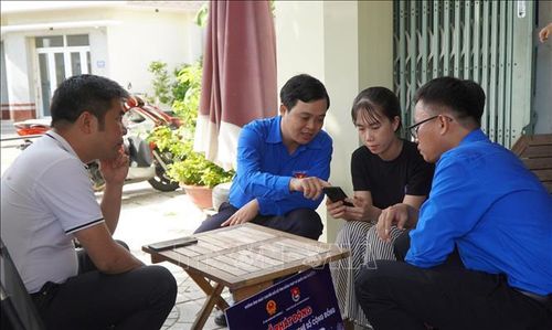 Lực lượng đoàn viên, thanh niên hướng dẫn người dân cài đặt ứng dụng e-Đồng Tháp. Ảnh: Nhựt An/TTXVN