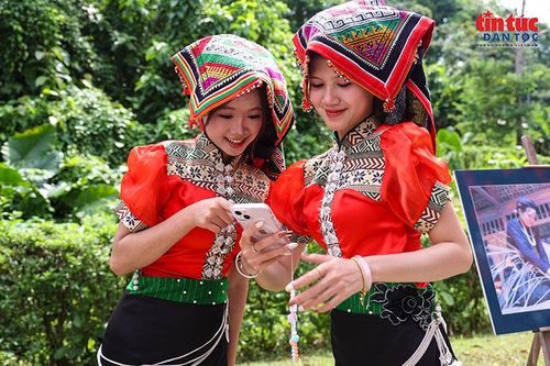 Các thiếu nữ trong trang phục dân tộc xem lại những hình ảnh lưu niệm tại ngày hội.