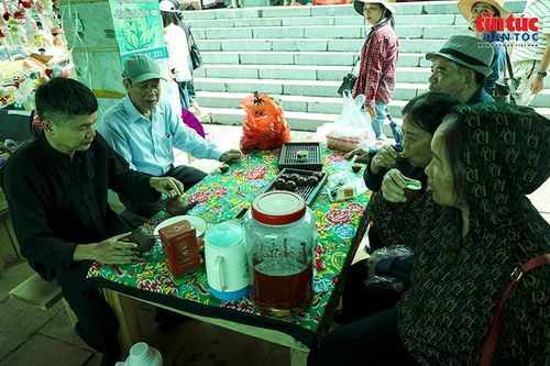 Người dân và du khách nghỉ chân, thưởng trà giữa không gian chợ phiên nhộn nhịp.