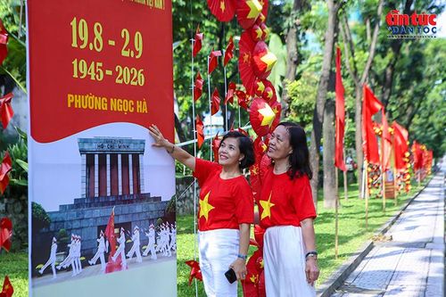 Người dân lưu lại hình ảnh kỷ niệm bên pano chào mừng Cách mạng Tháng Tám và Quốc khánh 2/9.