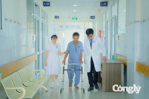 Sau ca phẫu thuật, anh P. có thể tập những bước đi đầu tiên với sự hỗ trợ của nhân viên y tế.