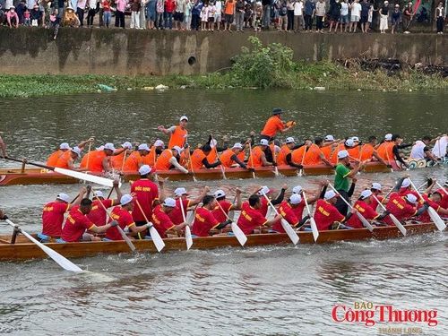 Người dân đứng dày đặc hai bên bờ sông xem các thuyền bơi tranh tài.