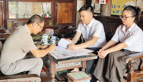 Thành viên Tổ hành chính công xung kích xã Sơn Động đến nhà hỗ trợ người dân giải quyết thủ tục hành chính.