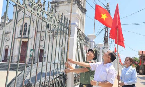 Đại tá Nguyễn Quốc Vương, Phó Giám đốc Công an tỉnh cùng Ban Hành giáo Giáo xứ Thanh Giã treo cờ Tổ quốc.