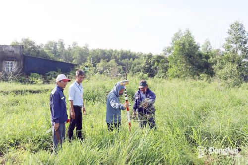 Lực lượng chức năng xã An Phước đo đạc, kiểm kê tài sản đất đai thu hồi làm dự án.