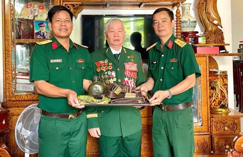 Anh hùng Nguyễn Văn Nhương (giữa) trao tặng một số kỷ vật chiến trường cho Bảo tàng Quân đoàn 34. Ảnh: P.D