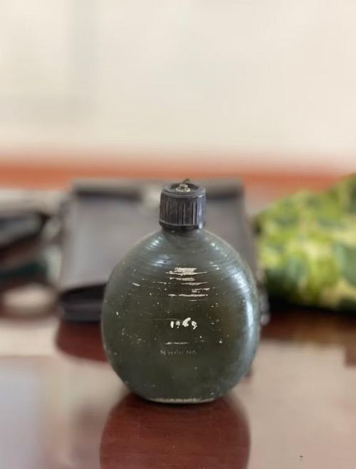Chiếc bi đông khắc tên “Nhương” bị móp một phần do từng đỡ giúp chủ nhân một mảnh bom. Ảnh: P.D