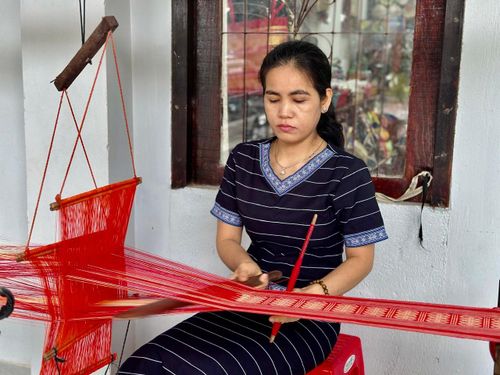 Nghệ nhân K' Nghị bên khung dệt