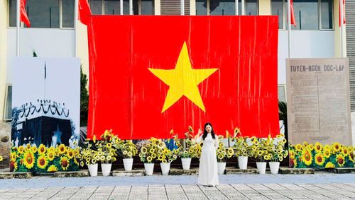 Du khách check-in dưới lá cờ Tổ quốc cỡ lớn được trang trí nổi bật tại Không gian văn hóa Việt Hưng. Ảnh: PV