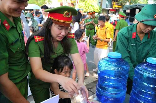 Dưới nắng hè, những lưng áo đẫm mồ hôi vẫn tiếp tục di chuyển giữa dòng người. Một tay làm nhiệm vụ, một tay trao chai nước; vừa điều tiết giao thông, vừa tận tình chỉ dẫn.